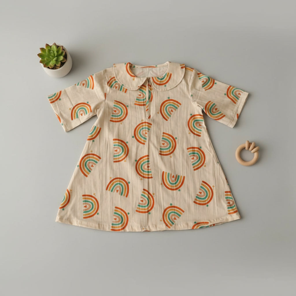 Children's shirt with rainbow pattern on a wooden surface